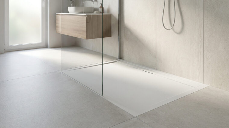 Receveur de douche blanc extra plat dans une salle de bain moderne avec paroi en verre et meuble vasque en bois.